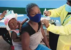  ?? DENIS FARRELL/ASSOCIATED PRESS ?? A baby cries as her mother receives the Pfizer vaccine near Johannesbu­rg, South Africa, in October. Scientists are studying a new variant, stoking fears the country may face a potentiall­y severe fourth wave of the coronaviru­s.