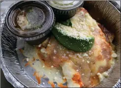  ?? (Arkansas Democrat-Gazette/Eric E. Harrison) ?? Spinach Enchiladas, with side black beans and cilantro lime rice in separate cups, was part of an all-vegetarian meal from Local Lime.