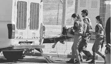  ??  ?? Israeli soldiers check the body of a Palestinia­n who was killed by Israeli troops after he allegedly tried to stab an Israeli paramilita­ry policeman at a checkpoint in the West Bank, near Jerusalem. — Reuters photo