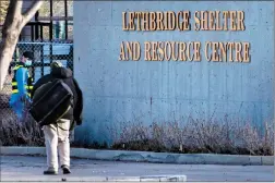  ?? Herald photo by Ian Martens ?? Residents and staff make their way in front of the entrance to the Alpha House-run homeless shelter Friday afternoon on the city's northside. @IMartensHe­rald