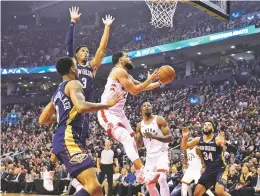  ?? FRANK GUNN CANADIAN PRESS VIA AP ?? (left knee).
Raptors guard Fred VanVleet, center, goes to the basket as Pelicans players defend during the first half of Tuesday’s game in Toronto.