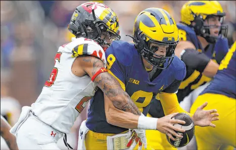  ?? Paul Sancya
The Associated Press ?? Maryland defensive back Gavin Gibson sacks Michigan quarterbac­k J.J. Mccarthy in the second half of a Big Ten game Saturday in Ann Arbor, Mich. The Wolverines were given a seven-point head start after Maryland fumbled the opening kickoff and went on to a 34-27 victory, but failed to cover as 17-point favorites.