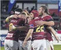  ??  ?? Feels good . . . (left) Southland celebrate their win against Otago after the teams' Mitre 10 Cup clash in Invercargi­ll last night. Right: Southland player fullback Rory van Vugt flies in the tackle of Otago flanker Slade McDowell.