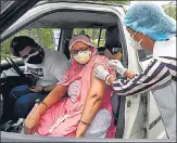  ?? PTI ?? A health worker administer­s a dose of vaccine to a woman at a drive-through vaccinatio­n camp in Noida on Monday.