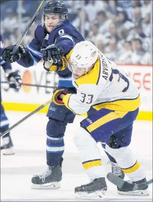  ?? CP PHOTO ?? Winnipeg Jets forward Andrew Copp, left, and Nashville Predators forward Viktor Arvidsson collide during secondperi­od action Monday in Winnipeg.