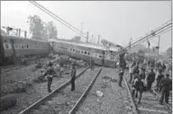  ??  ?? Rescuers and railway officials stand next to damaged coaches of a passenger train after it derailed near Kanpur in the northern state of Uttar Pradesh, India.(Photo: Reuters.com)