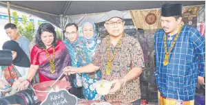  ?? — Gambar Chimon Upon ?? KEGEMARAN RAMAI: Aaron ditemani Timbalan Menteri Perpaduan Negara Senator Saraswathy Kandasami (kiri) serta yang lain semasa melawat gerai King Laksa Sarawak pada Program Foodunites Ini Warisan Kita di Tebingan Kuching, semalam.