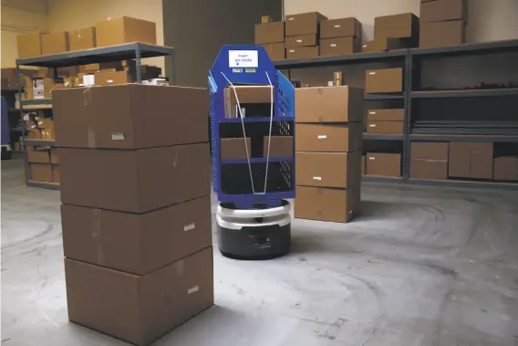  ?? Paul Chinn / The Chronicle ?? An autonomous robot designed to transport materials loaded by humans carries them on its own through the Fetch Robotics testing warehouse in San Jose.