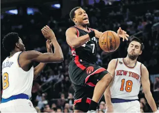  ?? PHOTOS: SETH WENIG/THE ASSOCIATED PRESS ?? Kyle Lowry, centre, loses control of the ball on the way to the basket during NBA action against the Knicks Sunday in New York. Lowry had 17 points in Toronto’s 110-97 victory.