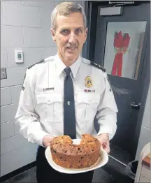  ?? COLIN MACLEAN/JOURNAL PIONEER ?? Summerside Police Service Deputy Chief Sinclair Walker with one of the many fruitcakes Ruth Waite has delivered to the station over the past 34 years.