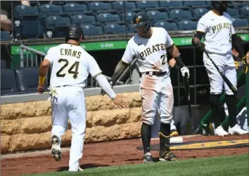  ?? Justin Berl/Getty Images ?? Phillip Evans celebrates with Kevin Newman after scoring on a single by Colin Moran in the fourth inning against the Chicago Cubs Sunday at PNC Park.