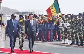  ?? THE ASSOCIATED PRESS ?? Senegal President Macky Sall, left, and Chinese President Xi Jinping inspect the honor guard during Saturday’s state visit in Dakar, Senegal.