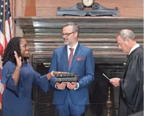  ?? FRED SCHILLING/COLLECTION OF THE U.S. SUPREME COURT ?? Chief Justice John Roberts swears in Ketanji Brown Jackson as her husband, Dr. Patrick Jackson, holds the Bible.