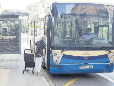  ??  ?? Una mujer provista con mascarilla pregunta al conductor de un autobús, en una parada de Castelló. ((
BATISTE SAFONT