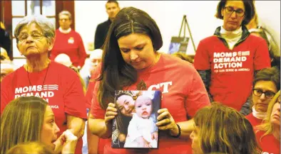  ??  ?? Erin Bond, of Bethel, holds a photo of her niece Emily Todd, who was murdered in Bridgeport in 2018, during a special statewide event hosted by Moms Demand Action for Gun Sense in America at the Margaret Morton Government Center in downtown Bridgeport on Saturday. The event concluded a weeklong series of local events in recognitio­n of National Survivors Week, Feb. 1- 8. It also featured a Moments That Survive Story Wall, a display of photos and personal stories from Connecticu­t gun violence survivors that illustrate the effect gun violence has had on their lives.