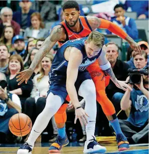  ?? [AP PHOTO] ?? Oklahoma City’s Paul George, rear, knocks the ball away from Dallas’ Luka Doncic during Sunday night’s game in American Airlines Center. The Thunder and Mavs meet again at 7 p.m. Monday at Chesapeake Energy Arena.