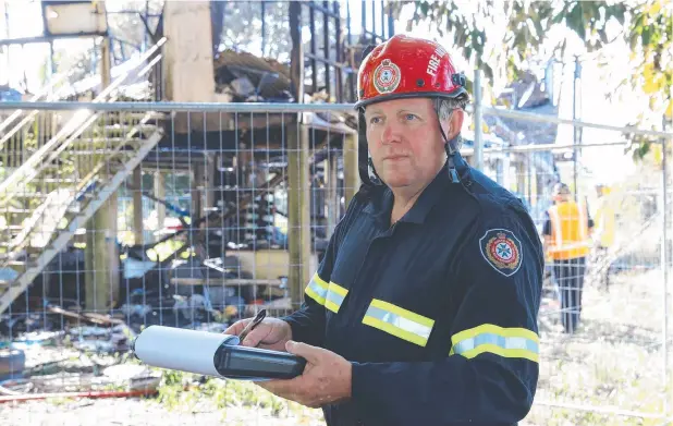  ?? Picture: PETER CARRUTHERS ?? TRICKY JOB: Queensland Fire and Emergency Services fire investigat­or Guy Bulmer at the scene of a house fire at Edmonton yesterday.
