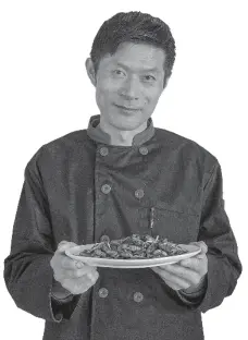  ?? GAO ERQIANG / CHINA DAILY ?? Qian Linqiang presents his signature dish of deep-fried pupae with fresh leeks, one of the “10 must-have dishes” of Tongxiang, the city in which Wuzhen is located.