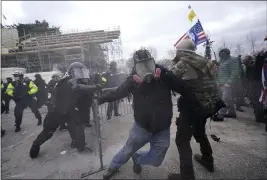  ?? JULIO CORTEZ — THE ASSOCIATED PRESS ?? Trump supporters try to break through a police barrier at the Capitol in Washington on Wednesday.