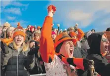  ??  ?? Fans cheer Washington’s football team during the semifinal loss in Springfiel­d. Ten of the team’s players lost their homes in the storm.