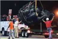  ??  ?? Workers remove a monument dedicated to the Confederat­e Women of Maryland on Wednesday. Below: Steve Damron, 50, of Spring Hill, Florida, holds up a sign during a Hillsborou­gh County Commission meeting about the moving of a Confederat­e statue.