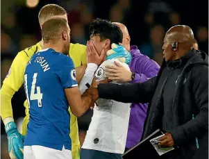  ??  ?? Tottenham forward Son Heung-min was inconsolab­le after being sent off following his late challenge on Andre Gomes.