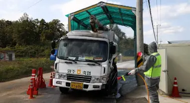  ??  ?? Swine fever fears have spread around Asia, as a worker gets ready to spray disinfecta­nt onto a truck at a cleansing checkpoint near a pig farm in Paju, South Korea. Photo: Bloomberg