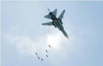  ??  ?? A Syrian government forces’ MiG-23 fighter-bomber drops a payload during a reported air strike in the rebel-held area of Qabun, east of the capital Damascus, on Saturday. -- AFP