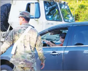  ?? AP PHOTO ?? A woman tries to talk to a national guardsmen to gain entry to the Leilani Estates, Friday, in Pahoa, Hawaii. A mandatory evacuation forced many residents to flee their homes due to a nearby lava eruption.