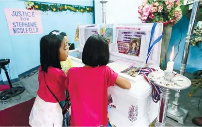  ?? (AP FOTO) ?? CHILDREN PAY their last respects to Stephanie Nicole Ella, 7, who was hit with a stray bullet as their family watch the fireworks to welcome the New Year, prior to her funeral in Caloocan City. Nicole’s death prompted civil society and church groups to...