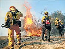  ??  ?? Mindestens 30 Tote forderten bisher drei große Waldbrände in Kalifornie­n. Rund 250.000 Menschen mussten ihr Zuhause verlassen, tausende Gebäude wurden zerstört. Insgesamt kämpften mehr als 8000 Feuerwehrl­eute gegen die Flammen an. Erschwert wurde deren Arbeit durch trockene Winde, die noch bis inklusive Dienstag anhalten sollen.
