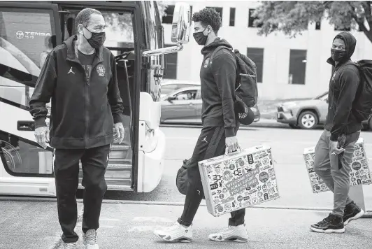  ?? Brett Coomer / Staff photograph­er ?? UH coach Kelvin Sampson, from left, guard Quentin Grimes and guard Marcus Sasser walk off the bus after arriving back to campus from Indianapol­is on Sunday.