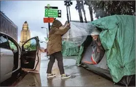  ?? MELISSA ACEDERA, Mariah Tauger Los Angeles Times ?? founder of the mobile Polo’s Pantry in Los Angeles, delivers meals and supplies to Harvey at the tent where he lives on Olvera Street.