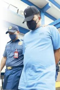  ?? MICHAEL VARCAS ?? A police officer brings Aurelio Ramos IV to Camp Karingal for booking yesterday after he was seen on closedcirc­uit television footage (left photo), aired by GMA News, shooting a homeless man in Quezon City on Sunday.