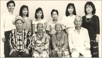  ?? ?? Photo from the family album shows a younger Caleena (right) and husband Jeffery (left) with their children, all standing behind the seated elders (from left) Jeffery’s parents Param Sewa and Doo Swea, together with Caleena’s parents Puun Aran and Puun Maran.