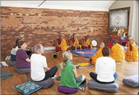  ?? RACHEL WISNIEWSKI — FOR DIGITAL FIRST MEDIA ?? Members of Yoga Tree at the Pennridge Wellness Center in Blooming Glen surround monks from the Gomang Drepung Monastery. Yoga Tree is hosting nine Tibetan Monks from June 13 through June 18 as a part of the monks’ annual Sacred Art Tour.