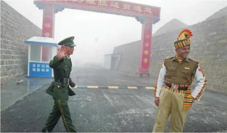  ?? — AFP file ?? A Chinese soldier next to an Indian soldier at the Nathu La border crossing between India and China in India’s northeaste­rn Sikkim state.