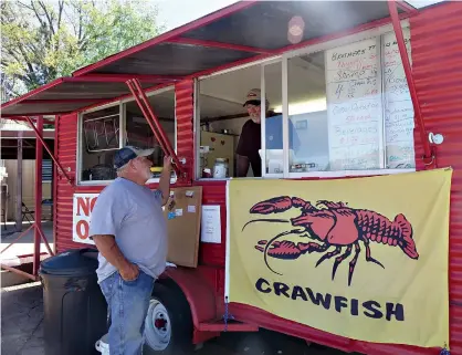  ?? Staff photos by Neil Abeles ?? n Curtis Whitlow, left, and his brother Tony wait for customers at the Brothers Mudbugs serving window of the trailer Curtis built.