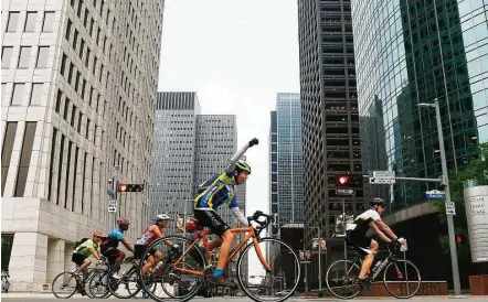  ?? Michael Ciaglo / Houston Chronicle ?? Cyclists head down Smith Street during the start of Tour de Houston on Sunday. The 60-, 40- or 20-mile fundraisin­g bike rides benefit Houston's Reforestat­ion Program. The event usually raises around $100,000.