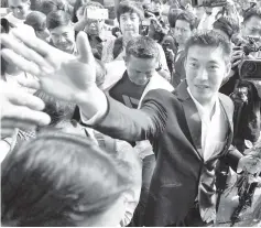  ??  ?? Thanathorn greets supporters on arrival at the Office of the Attorney General in Bangkok. — AFP photo