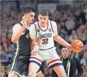  ?? ROBERT DEUTSCH/USA TODAY SPORTS ?? Connecticu­t center Donovan Clingan, right, works against Purdue center Zach Edey in the national championsh­ip game on April 8. Clingan and Edey are expected to be lottery picks in this summer’s NBA draft.