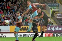  ?? PHOTO: REUTERS ?? Chris Wood, centre, soars high to head Burnley’s equaliser in a 1-1 draw with West Ham, captained by All Whites team-mate Winston Reid.