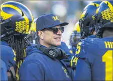  ?? TONY DING — THE ASSOCIATED PRESS FILE ?? In this Nov. 16, 2019, file photo, Michigan head coach Jim Harbaugh huddles with his players on the field during a time out in the fourth quarter of a game against Michigan State in Ann Arbor, Mich.