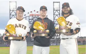  ?? Thearon W. Henderson / Getty Images ?? Gold Glove winners Joe Panik (left), Buster Posey and Brandon Crawford show off their gilded trophies before the game against the Diamondbac­ks at AT&T Park, a game Posey sat out on the disabled list after getting hit in the helmet by a pitch.