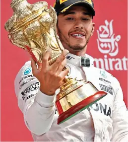  ?? REUTERS ?? Trophy life: Hamilton celebrates at Silverston­e last year