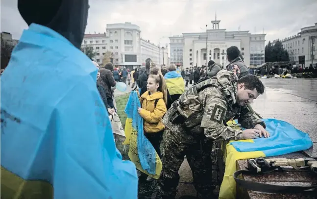  ?? Chris McGr  h   G ?? Soldats ucraïnesos firmant banderes d’Ucraïna al centre de Kherson