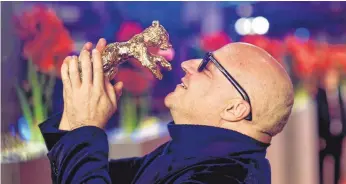  ?? FOTO: DPA ?? Gianfranco Rosi liebkost seinen Goldenen Bären, den er für seinen Film „Fuocoammar­e“erhielt.