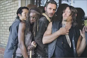  ?? Gene Page AMC ?? STEVEN YEUN, left, Danai Gurira, Andrew Lincoln and Norman Reedus on the set of “The Walking Dead.”