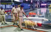  ?? — PTI ?? Police personnel along with a sniffer dog during a search operation at CSMT after receiving a bomb threat call by an unknown person in Mumbai.