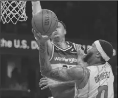  ?? Associated Press ?? Washington Wizards forward Kyle Kuzma tries to block a shot by Charlotte Hornets forward Miles Bridges (0) during the first half of an NBA basketball game on Friday in Washington.